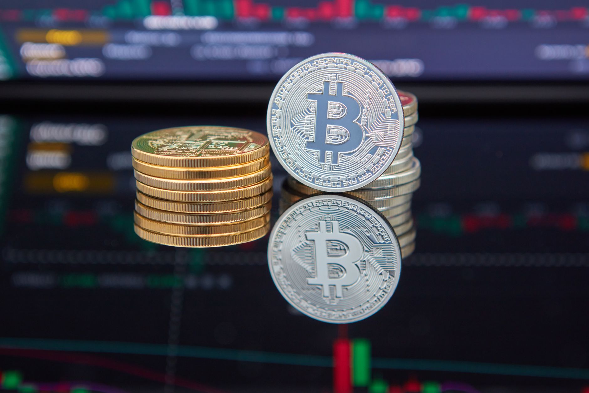 Bitcoin coins stacked in front of a rising cryptocurrency trading chart, symbolizing the breakout rally toward the $83,000 bull-market confirmation line