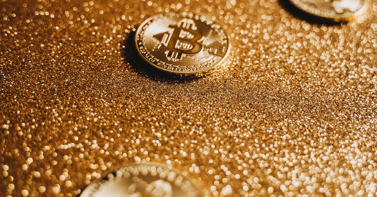 Bitcoin coins beside a rising trading chart, capturing the $77K policy rally fueled by the CLARITY Act and Treasury buybacks