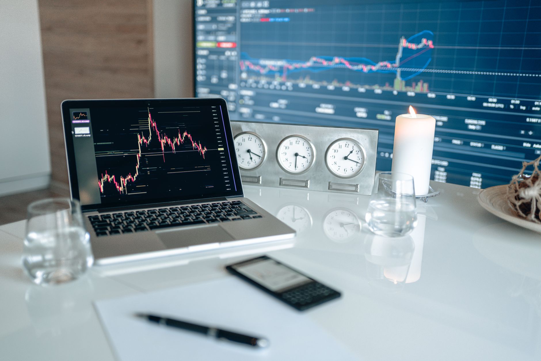 Candlestick charts and three market clocks across a trading desk as investors brace for CPI, a Federal Reserve rate decision and a Senate vote