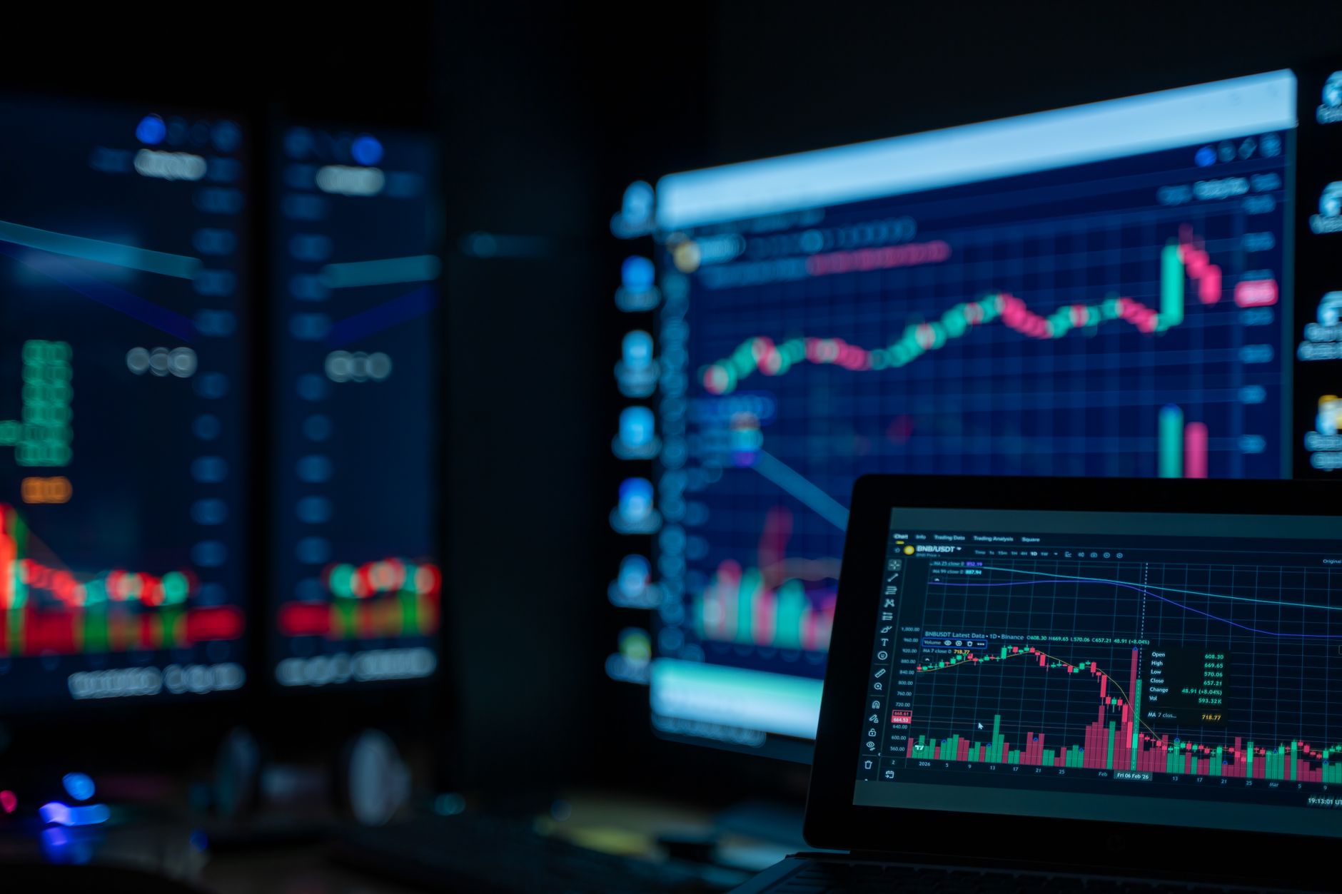 Monitors displaying stock market charts in a dimly lit trading room as crypto decouples from an AI-led equity selloff